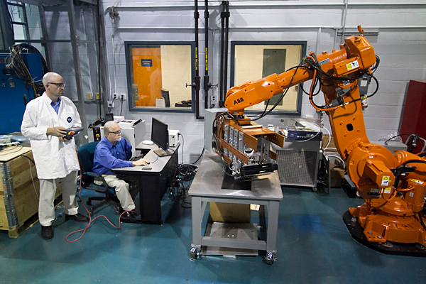 researchers near a robotic arm